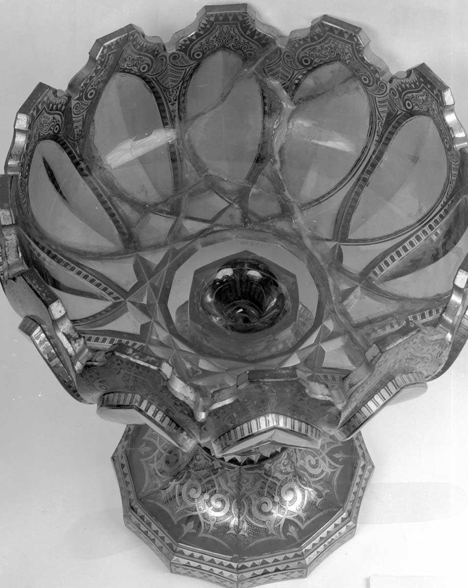 The cranberry punch bowl before treatment, showing previously repaired breaklines filled with excessive amount of adhesive.