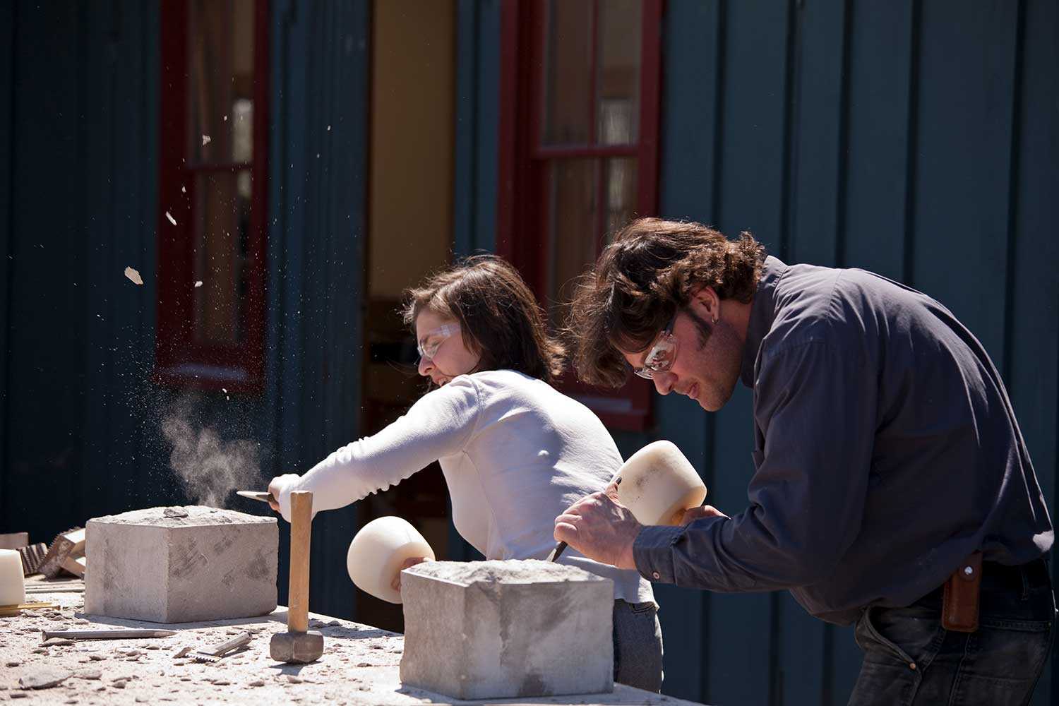 Master mason and Willowbank Faculty Associate Danny Barber works alongside student Emily Kszan as she hones her skills squaring up a limestone block (Photo courtesy of Willowbank School of Restoration Arts)